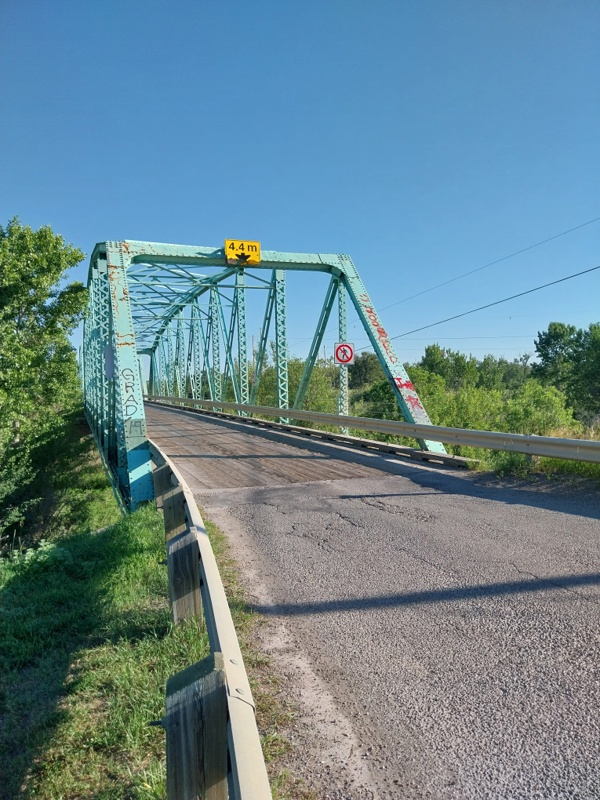 Stahl-Bogenbrücke mit der hölzernen Fahrbahn