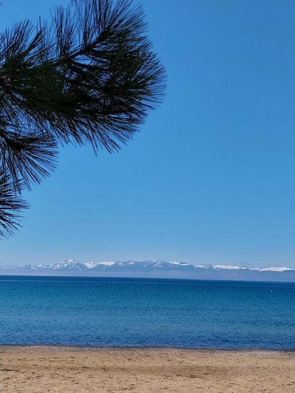 Lake Tahoe mit Sand und Schneebergen